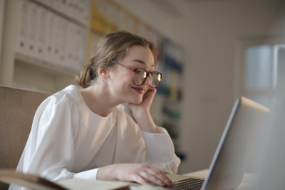 Image d'une personne souriante travaillant seule sur une ordinateur
