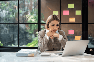 Image d'une jeune femme dans un bureau concentrée sur son écran d'ordinateur